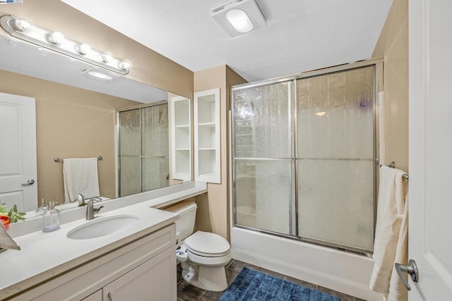 full bathroom with tile floors, combined bath / shower with glass door, oversized vanity, and toilet