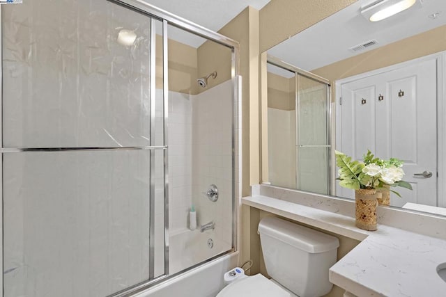 full bathroom with shower / bath combination with glass door, vanity, and toilet