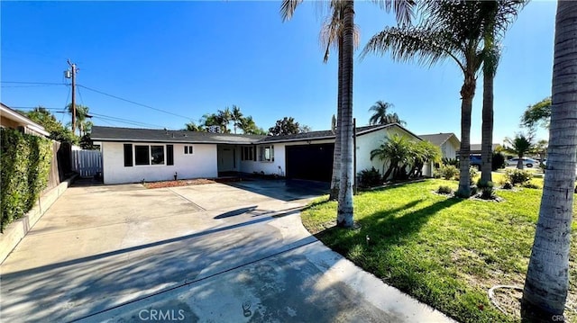 ranch-style home featuring a garage and a front lawn