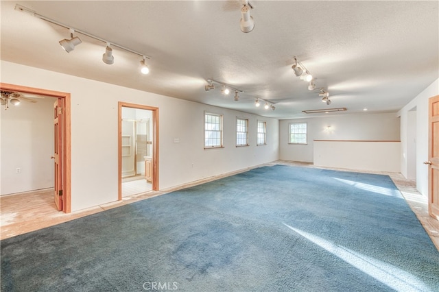 interior space featuring light colored carpet and a textured ceiling