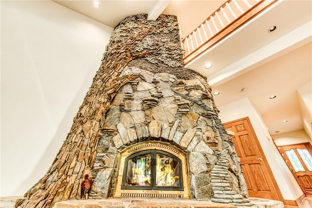 interior details featuring a stone fireplace and beamed ceiling