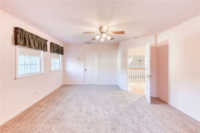 carpeted spare room featuring ceiling fan