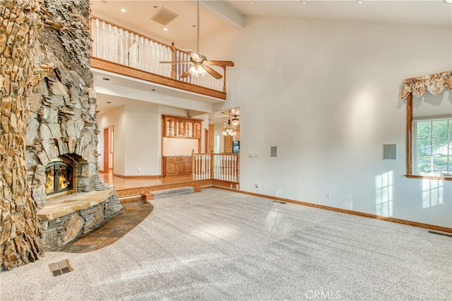 unfurnished living room with ceiling fan, carpet floors, a fireplace, beam ceiling, and high vaulted ceiling