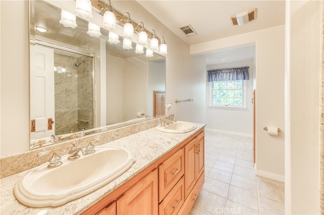 bathroom with walk in shower, vanity, and tile patterned flooring