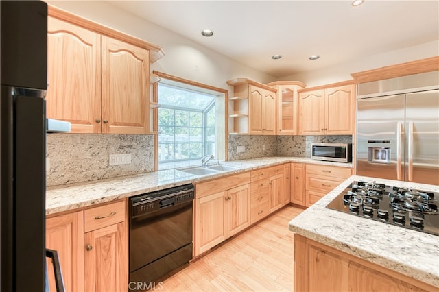 kitchen with tasteful backsplash, appliances with stainless steel finishes, light brown cabinets, and light hardwood / wood-style flooring