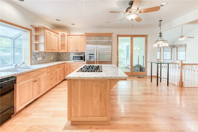 kitchen with stainless steel appliances, backsplash, light brown cabinets, a kitchen island, and sink