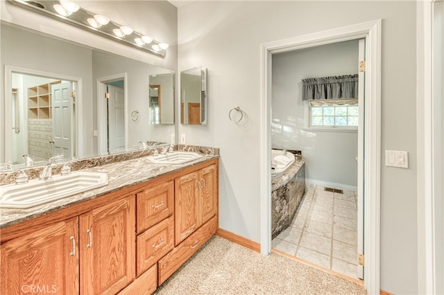 bathroom featuring tile patterned flooring, a bath, and vanity