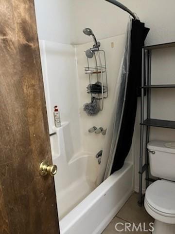 bathroom featuring tile patterned flooring, shower / bath combination with curtain, and toilet