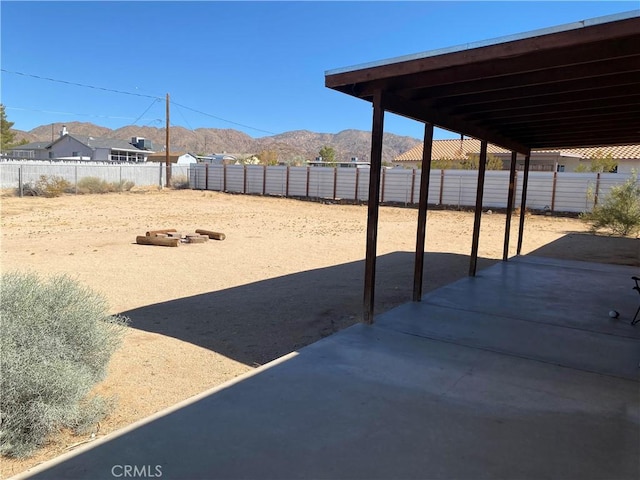 view of yard with a patio, fence, and a mountain view