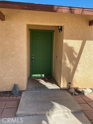 entrance to property featuring stucco siding