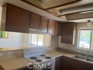 kitchen featuring white stove, ventilation hood, and sink