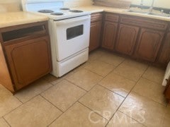 kitchen featuring light tile patterned floors, sink, and white electric range