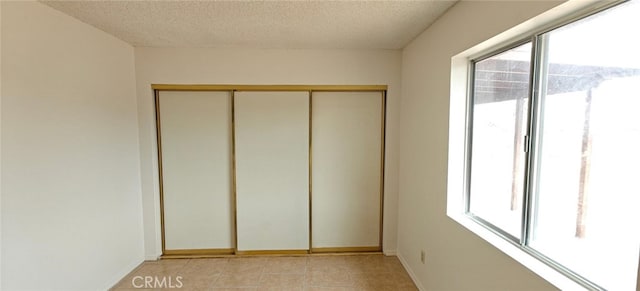 empty room with a textured ceiling and baseboards