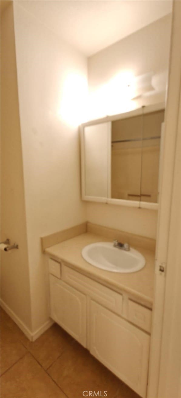 bathroom with vanity, tile patterned floors, and baseboards