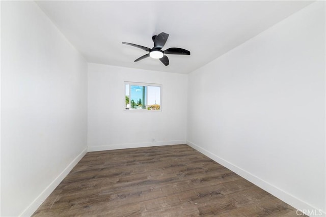 spare room featuring dark wood-type flooring and ceiling fan