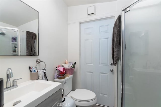 bathroom with walk in shower, vanity, and toilet