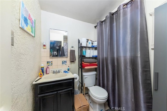 bathroom with vanity, backsplash, and toilet