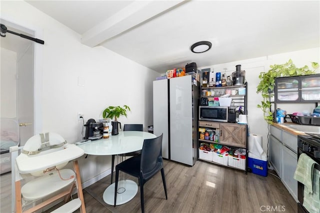 kitchen with beamed ceiling, dishwashing machine, hardwood / wood-style flooring, white refrigerator, and a barn door