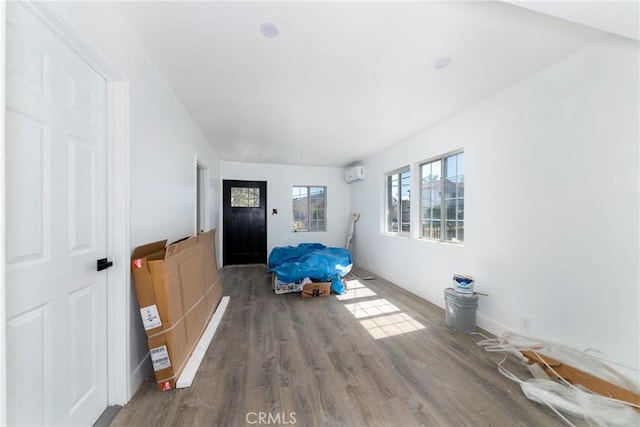 interior space featuring hardwood / wood-style flooring and a wall mounted air conditioner