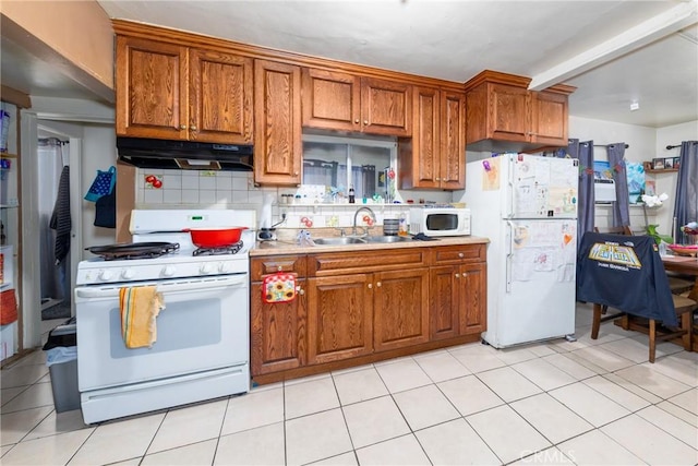 kitchen featuring tasteful backsplash, white appliances, sink, and light tile patterned floors