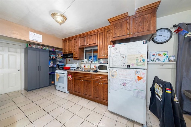 kitchen featuring white appliances and light tile patterned flooring