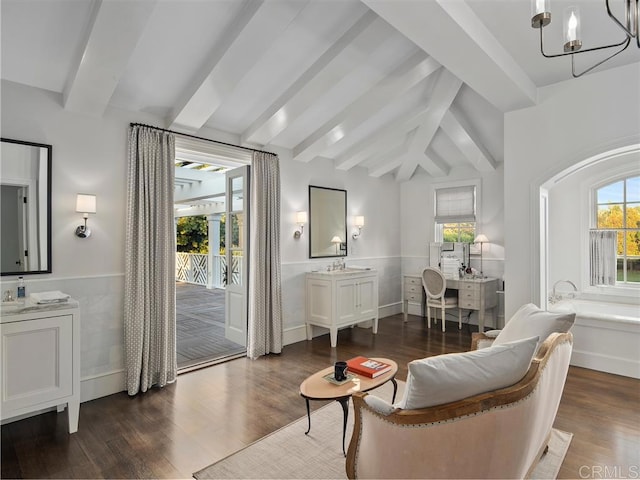 living area with lofted ceiling with beams, dark wood-type flooring, a chandelier, and a healthy amount of sunlight