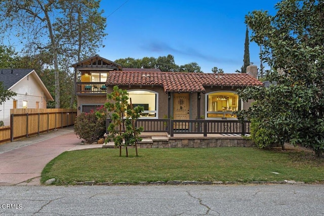 view of front of home featuring a balcony and a front yard