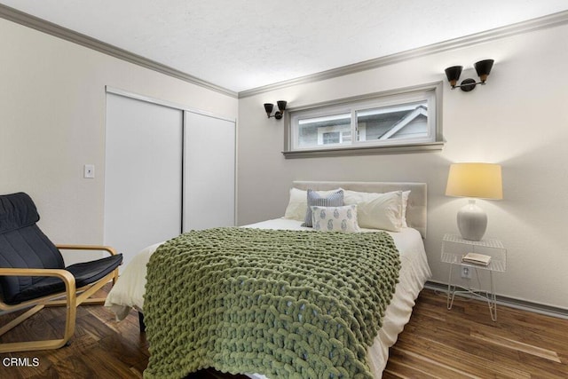 bedroom with ornamental molding, dark hardwood / wood-style floors, a textured ceiling, and a closet