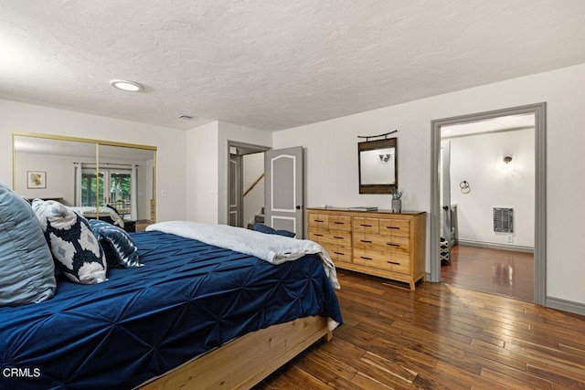 bedroom featuring dark hardwood / wood-style floors and a textured ceiling