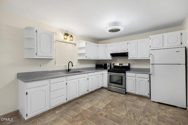 kitchen with white refrigerator, white cabinetry, sink, and stainless steel range with gas stovetop