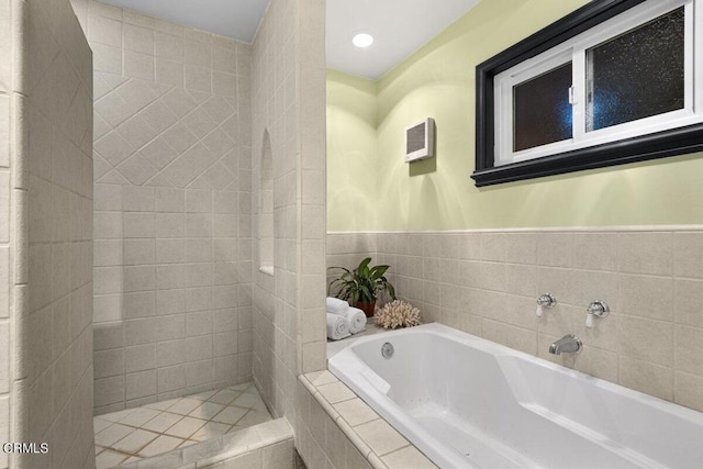 bathroom with a relaxing tiled tub