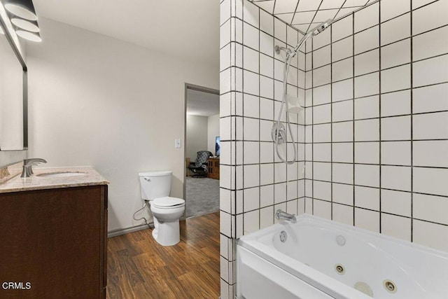 full bathroom with hardwood / wood-style flooring, vanity, toilet, and tiled shower / bath combo