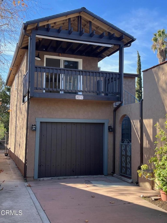 view of front of property featuring a garage and a balcony