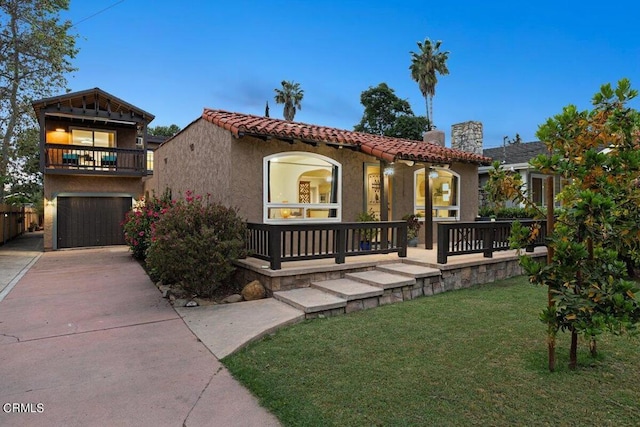 mediterranean / spanish-style home featuring a balcony, a yard, and a garage