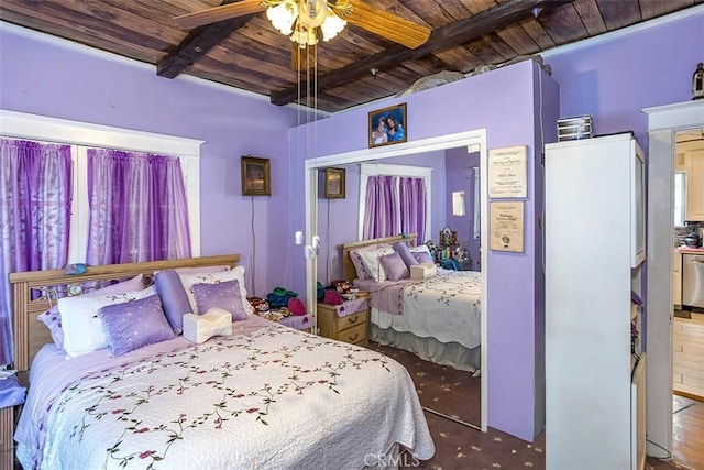 bedroom with ceiling fan, a closet, beamed ceiling, and wooden ceiling