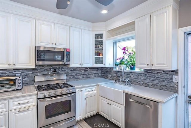 kitchen with sink, white cabinetry, backsplash, and stainless steel appliances