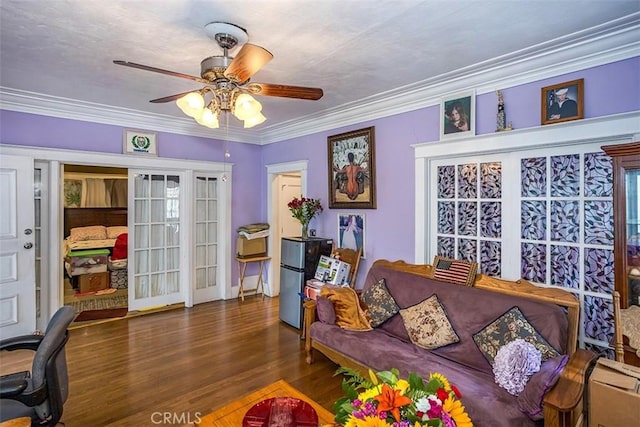 living room with ceiling fan, dark wood-type flooring, and ornamental molding