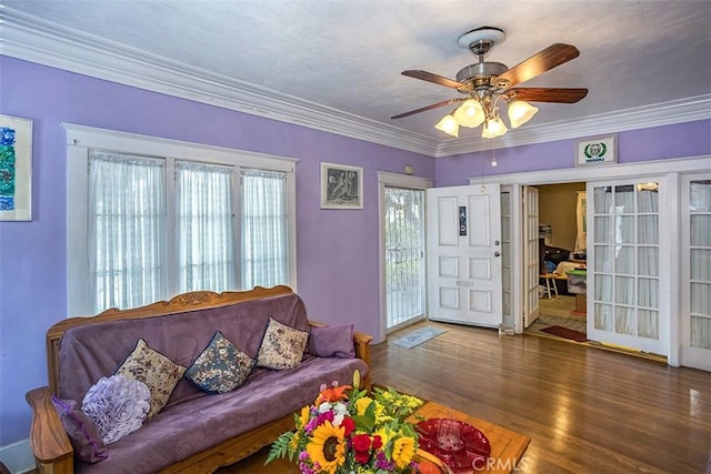 living room featuring ceiling fan, wood-type flooring, and crown molding