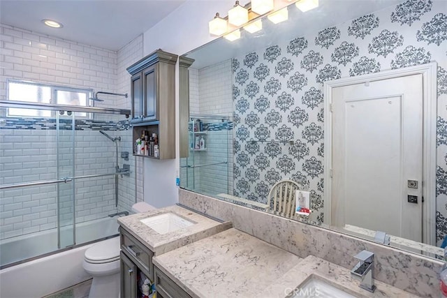 full bathroom featuring toilet, vanity, and bath / shower combo with glass door