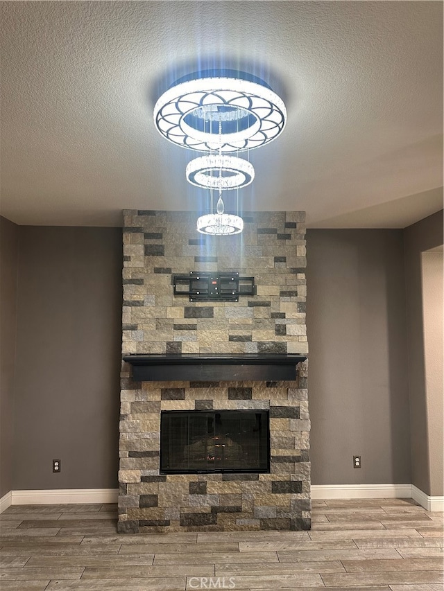 room details with hardwood / wood-style floors, a textured ceiling, and a fireplace