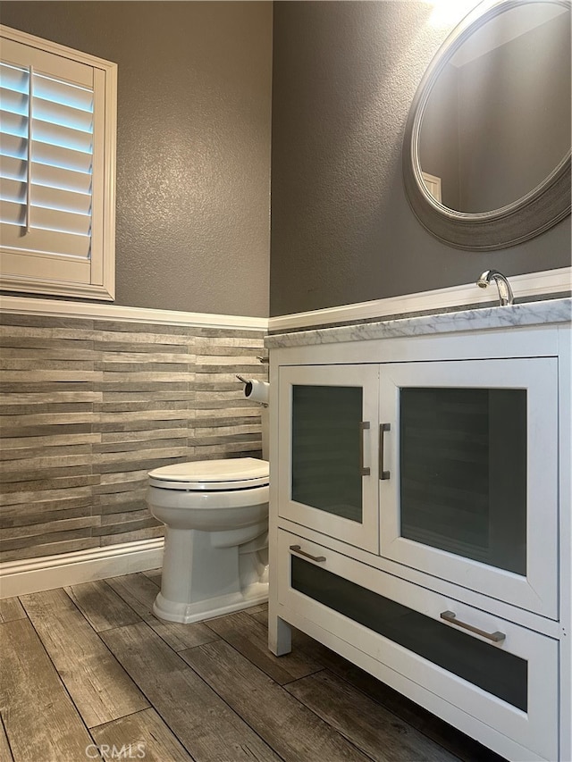 bathroom with hardwood / wood-style flooring, vanity, and toilet