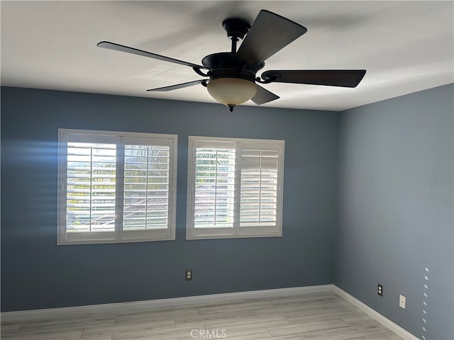 spare room with ceiling fan and light wood-type flooring