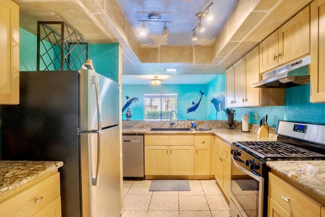 kitchen featuring sink, light brown cabinets, stainless steel appliances, light stone counters, and light tile patterned floors