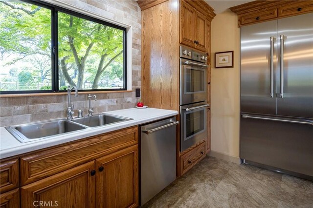 kitchen with decorative backsplash, sink, plenty of natural light, and appliances with stainless steel finishes