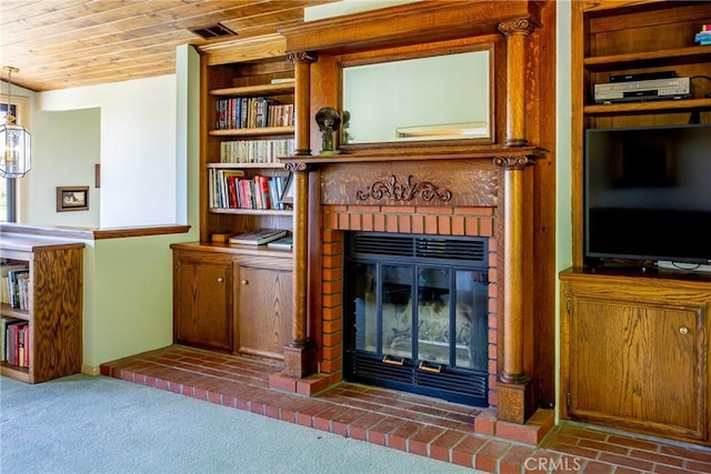 unfurnished living room with carpet, wood ceiling, and a brick fireplace