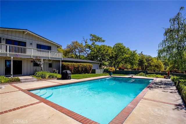 view of swimming pool with a patio and a diving board