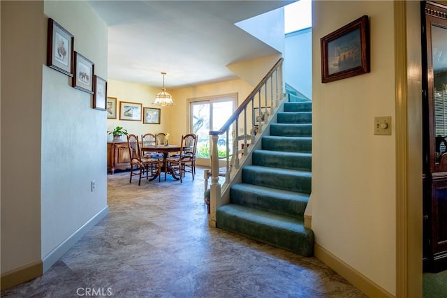 staircase with a chandelier