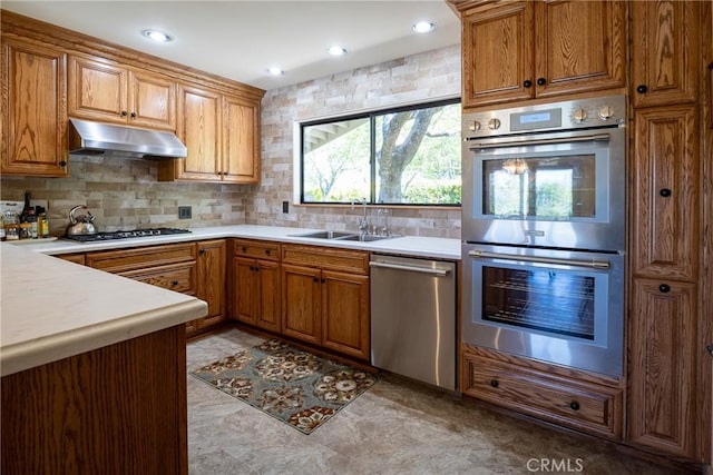 kitchen featuring stainless steel appliances, tasteful backsplash, and sink