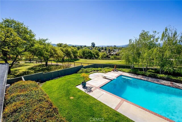 view of swimming pool with a diving board, a patio area, and a lawn