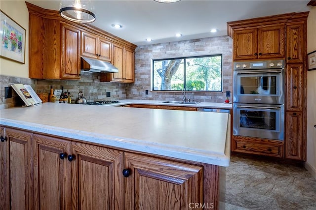 kitchen featuring backsplash, sink, and appliances with stainless steel finishes